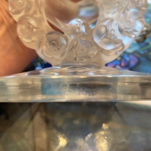 K&ouml;nnte beinhalten: Eine klare Glasvase mit Blumenmuster. Die Vase ist mit einem erhabenen Blumenmuster verziert und hat einen klaren Glasfu&szlig;.