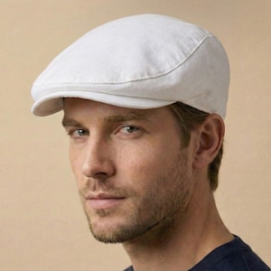 May include: A white linen newsboy cap. The cap has a rounded crown and a small, stiff brim. The fabric appears to be lightweight and breathable, suitable for warmer weather. The cap is a classic style, often associated with casual or vintage fashion.
