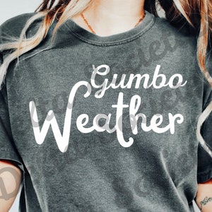 Könnte beinhalten: Ein graues T-Shirt mit dem Text "Gumbo Weather" in weißer Kursivschrift.