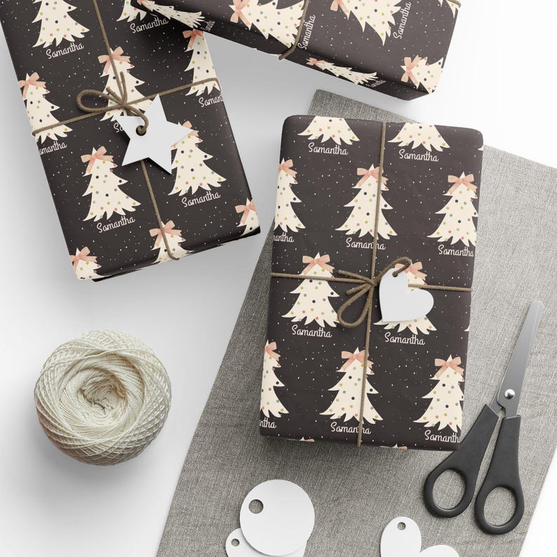 May include: A black and white wrapping paper with a repeating pattern of stylized Christmas trees with gold dots and pink bows. The name "Samantha" is repeated throughout the pattern.