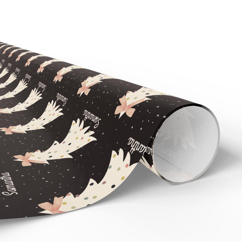 May include: Black wrapping paper with a repeating pattern of white Christmas trees with gold and pink polka dots and a pink bow. The text "Samantha" is repeated throughout the pattern.