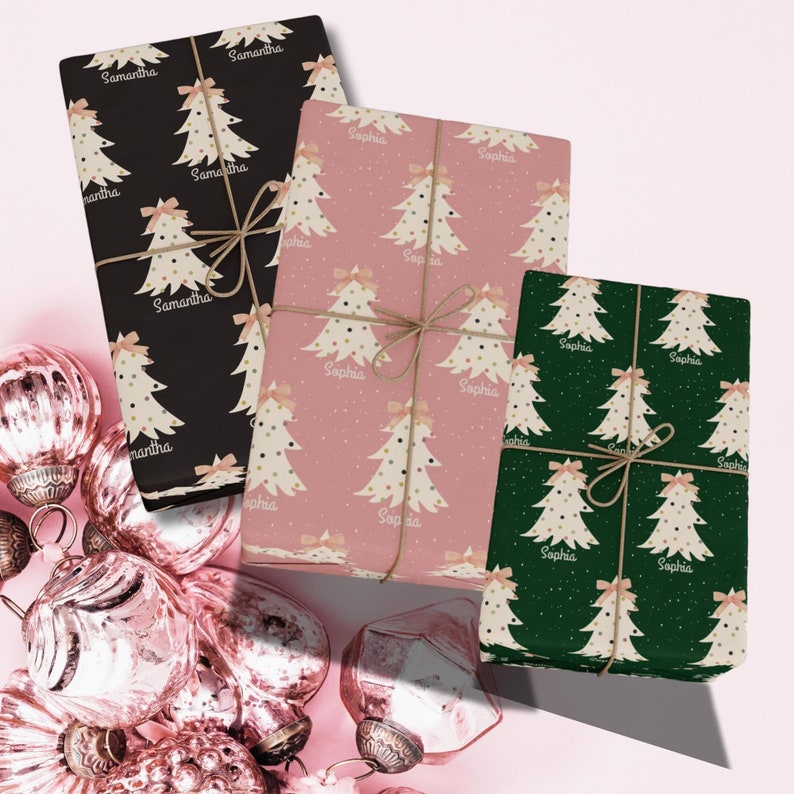 May include: Three Christmas gift wrapping paper designs with a white stylized Christmas tree pattern. The paper on the left is black with the name Samantha repeated on the paper. The paper in the center is pink with the name Sophia repeated on the paper. The paper on the right is green with the name Sophia repeated on the paper.