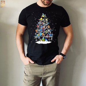 May include: A black t-shirt with a Christmas tree design featuring a variety of colorful birds. The birds are arranged in a tree shape with a white base and snowflakes.