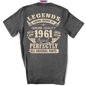 Op de afbeelding: Donkergrijs t-shirt met een vintage-stijl grafische afbeelding met de tekst "Legends were born in 1961 Aged Perfectly All Original Parts".