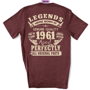 Op de afbeelding: Een maroon t-shirt met een vintage-stijl grafische afbeelding met de tekst "Legends Were Born In 1961 Aged Perfectly All Original Parts".