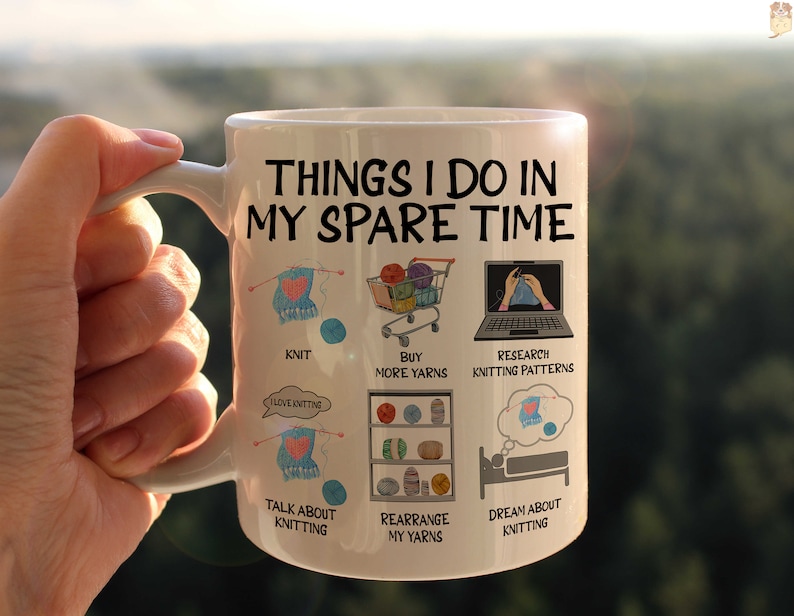 May include: White ceramic mug with a black and white illustration of knitting-related activities. The text on the mug reads "Things I do in my spare time".