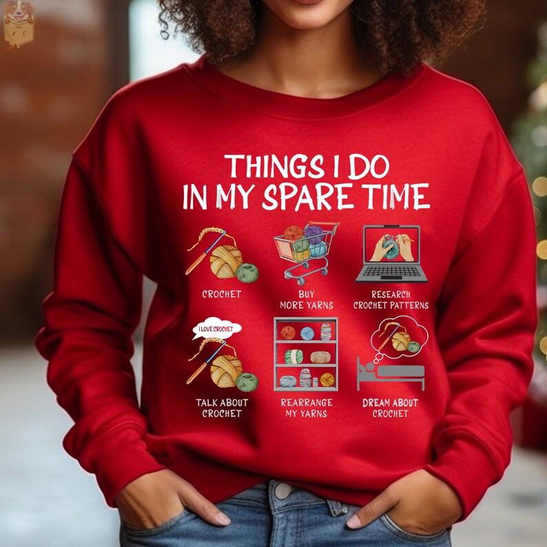 May include: Red sweatshirt with the text "Things I do in my spare time" and illustrations of crocheting, buying yarn, researching crochet patterns, talking about crochet, rearranging yarn, and dreaming about crochet.