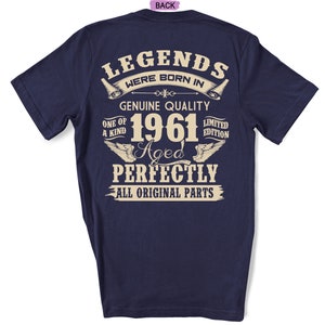 Op de afbeelding: Een marineblauw t-shirt met een witte afbeelding met de tekst "Legends were born in 1961 Aged Perfectly All Original Parts".