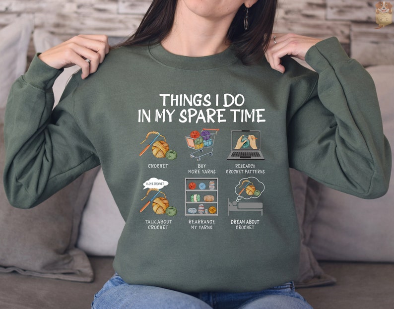 May include: A green sweatshirt with the text "Things I do in my spare time" and a list of activities related to crocheting, including "crochet", "buy more yarns", "research crochet patterns", "talk about crochet", "rearrange my yarns", and "dream about crochet".