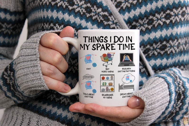 May include: White ceramic mug with a black and white illustration of things to do in your spare time, including knitting, buying yarn, researching knitting patterns, talking about knitting, rearranging yarn, and dreaming about knitting.