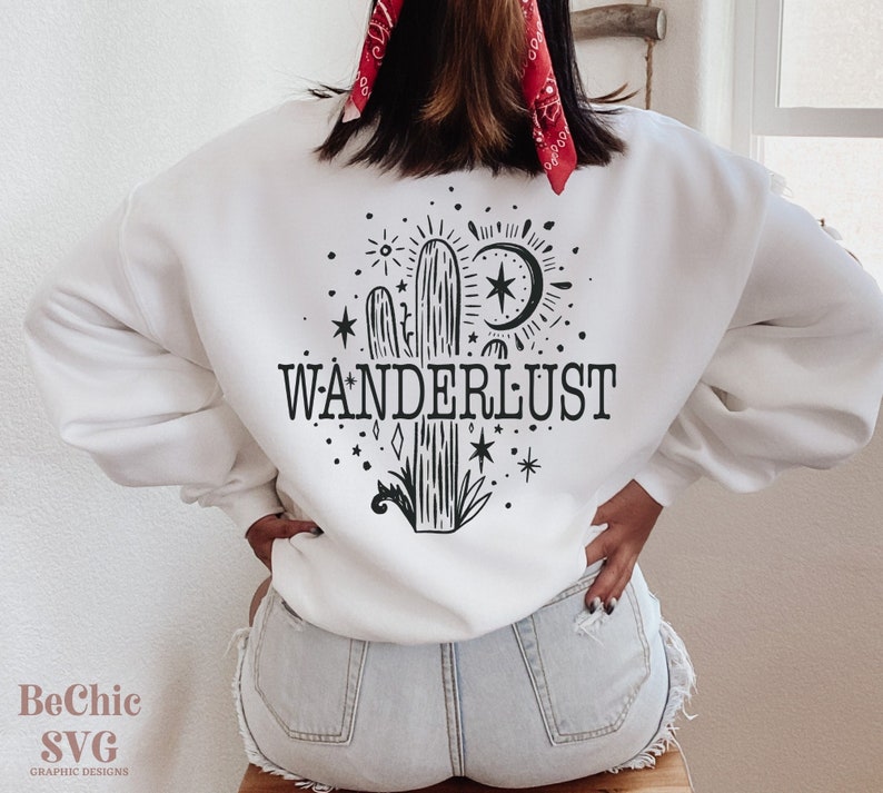 May include: White sweatshirt with a black and white graphic of a cactus, a crescent moon, stars, and the word "WANDERLUST".
