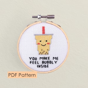 May include: A cross-stitch pattern featuring a cartoon bubble tea cup with a smiling face and the text "You make me feel bubbly inside".