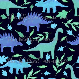 May include: A repeating pattern featuring watercolor dinosaurs in shades of blue and green, along with green leaves and blue leaf shapes, set against a dark navy background. The text "the blessed mama co." is repeated throughout the design.
