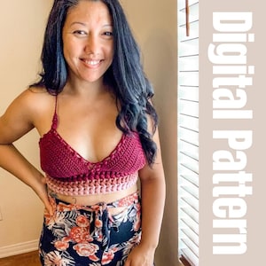 May include: A woman wearing a maroon crochet top with a pink and white crocheted trim. The top is a halter style and has a tie at the back. The woman is wearing a floral print skirt.