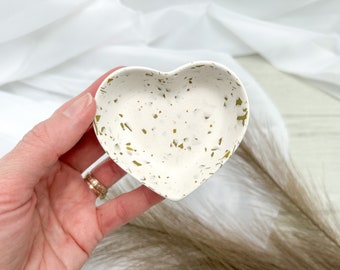 May include: White heart-shaped trinket dish with gold flecks.