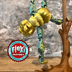 May include: A gold and teal articulated sloth toy hanging from a brown branch. The toy is made of flexible plastic and has a playful expression. The toy is labeled "Flexi Factory Authorized Seller".