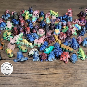 May include: A collection of colorful, hand-painted, miniature figurines in various animal and creature shapes. The figurines are made of a smooth, glossy material and have intricate details.