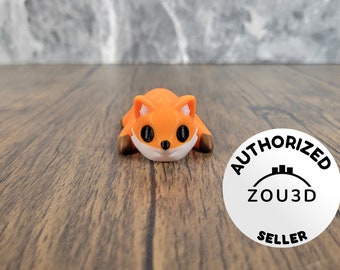 May include: Orange and white fox figurine with black eyes, lying on a wooden surface. The figurine is a 3D printed model. A white circle with black text reads "AUTHORIZED ZOU3D SELLER".