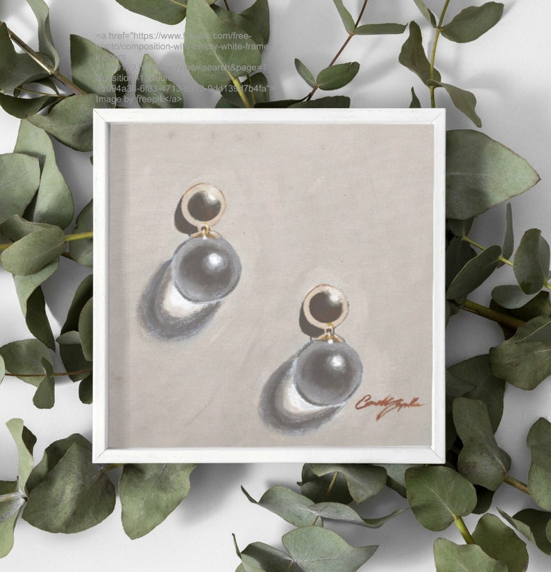 May include: A pair of gold and gray pearl earrings with a simple design. The earrings are displayed on a light brown background.
