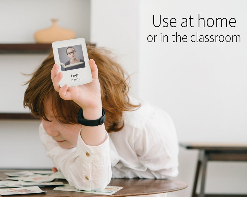 Puede incluir: Un ni&ntilde;o sostiene una tarjeta blanca con una imagen de una mujer leyendo un libro. La tarjeta dice "Leer to read" y el texto "Use at home or in the classroom" es visible en el fondo.