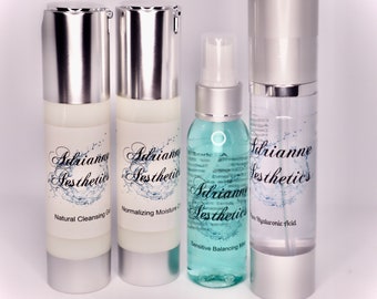 May include: Four skincare products in clear and silver containers. The products include a natural cleansing gel, normalizing moisture, sensitive balancing mist, and pure hyaluronic acid. Each bottle has a label with the brand name "Adrianne Aesthetics".