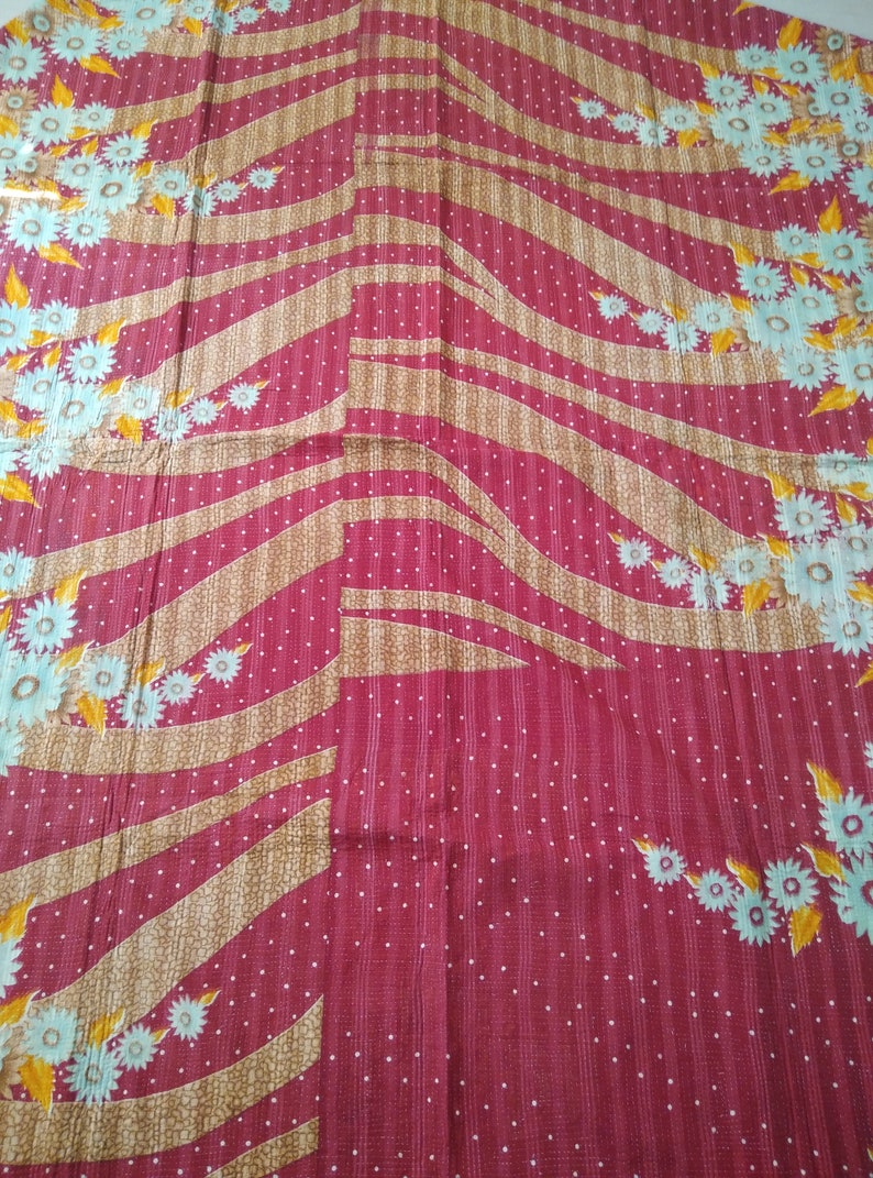 May include: A red fabric with a white polka dot pattern and a brown and white striped pattern. The fabric has a floral design with yellow and blue flowers.