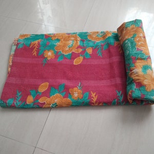 May include: A pink and green floral kantha quilt with a striped pattern. The quilt is rolled up and ready to be used.