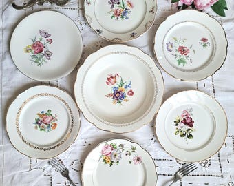 Mismatched antique earthenware dinner plates with gold trim accompanied by a dish