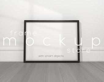 May include: A black picture frame mockup with the text "frame mockup store with smart objects" on a white wall with a wood floor.