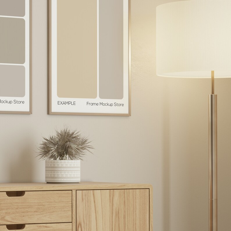 May include: A room interior featuring a wooden cabinet with a decorative plant in a patterned pot. Two framed art prints hang above the cabinet. The prints have a beige and light brown color scheme. A floor lamp with a white shade is on the right.
