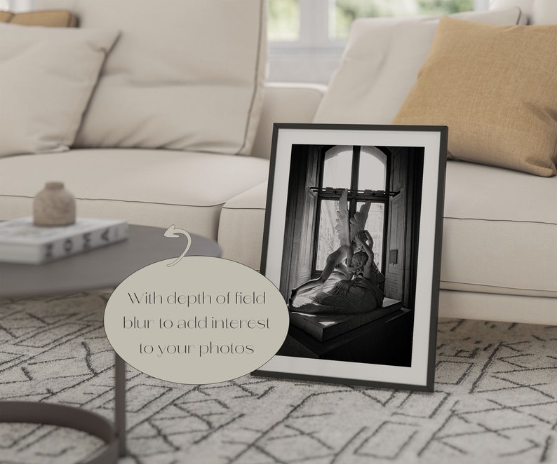 May include: A black and white photograph of a sculpture of two figures embracing, framed in a black frame. The sculpture is set against a window with a view of a building.
