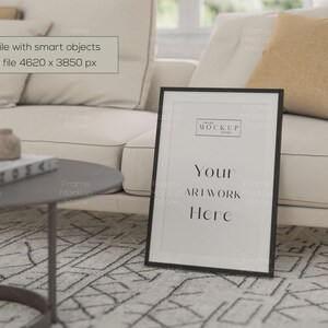 May include: A black picture frame with a white mat and a white background. The frame is sitting on a white couch with a brown throw pillow. The text "Your Artwork Here" is printed in black on the white background.