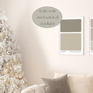 May include: A white Christmas tree decorated with gold ornaments and white flocking, a white couch with a gray throw pillow, and two white picture frames with gray and beige color swatches. The text "With soft and natural daylight" is written in a circle above the frames.