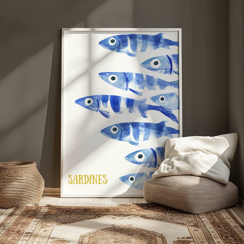 K&ouml;nnte beinhalten: Ein Aquarellbild einer Schule von blauen Sardinen auf wei&szlig;em Hintergrund. Das Wort "SARDINEN" ist in goldenen Buchstaben am unteren Rand des Bildes geschrieben.