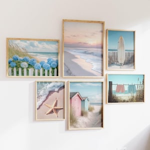 Puede incluir: Una colección de seis impresiones artísticas enmarcadas con temática de playa. Las impresiones presentan escenas del océano, incluyendo una playa con una tabla de surf, una estrella de mar en la arena y cabañas de playa. Los marcos son de madera clara.