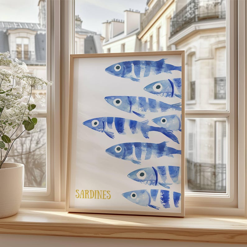 K&ouml;nnte beinhalten: Ein gerahmter Aquarelldruck einer Schule von blauen und wei&szlig;en Sardinen, die in einer Reihe schwimmen. Der Druck hat das Wort "SARDINEN" in Gelb unten geschrieben.