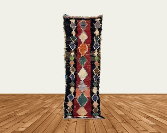 Puede incluir: Una alfombra larga y estrecha con un patrón geométrico colorido. La alfombra está tejida con una variedad de colores, incluyendo rojo, azul, verde y blanco. La alfombra tiene flecos en ambos extremos.