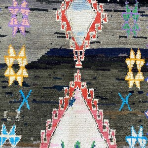 May include: A colorful Moroccan rug with a geometric pattern in shades of red, blue, yellow, green, and pink. The rug has a dark background and a white center.