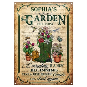 Könnte beinhalten: Ein Vintage-Schild aus Metall mit Gartenmotiv. Es zeigt einen grünen Stiefel, Blumen, eine Gießkanne und Gartengeräte. Das Schild trägt die Aufschrift "Sophia's Garden Est. 2024" und den Spruch "Jeder Tag ist ein Neuanfang. Atme tief durch. Lächle und beginne von Neuem."