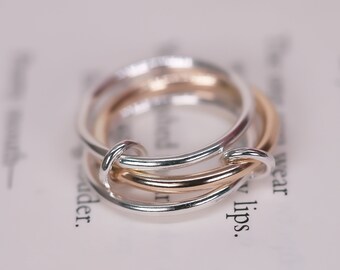 May include: Two-toned ring with a silver band and a gold band intertwined. The bands are smooth and polished.