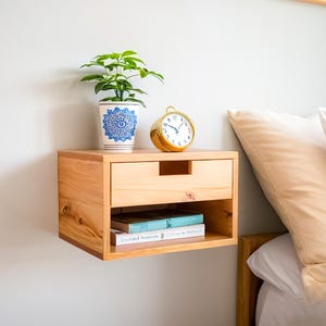 Here is a floating nightstand made of wood placed on the wall in the bedroom. It can also be used in the living room, living room.

Overall Dimensions:
H 10.75 inch, L 16.5 inch, D 14 inch