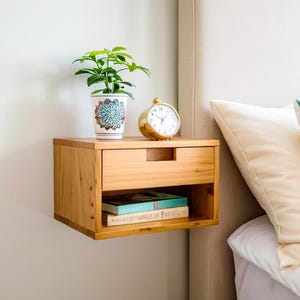 Here is a floating nightstand made of wood placed on the wall in the bedroom. It can also be used in the living room, living room.

Overall Dimensions:
H 10.75 inch, L 16.5 inch, D 14 inch