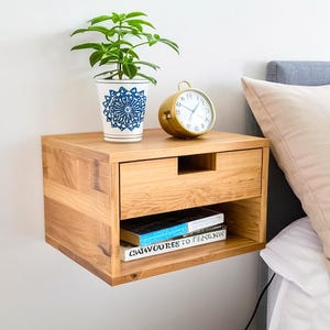 Here is a floating nightstand made of wood placed on the wall in the bedroom. It can also be used in the living room, living room.

Overall Dimensions:
H 10.75 inch, L 16.5 inch, D 14 inch