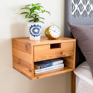 Here is a floating nightstand made of wood placed on the wall in the bedroom. It can also be used in the living room, living room.

Overall Dimensions:
H 10.75 inch, L 16.5 inch, D 14 inch