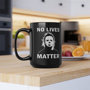 May include: Black coffee mug with a white graphic of Michael Myers from the Halloween movies. The graphic says "No Lives Matter".