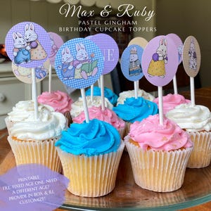 May include: A collection of cupcakes topped with circular paper decorations featuring Max and Ruby illustrations. The toppers display pastel gingham patterns and various scenes of the rabbit characters. The cupcakes have blue and pink frosting.