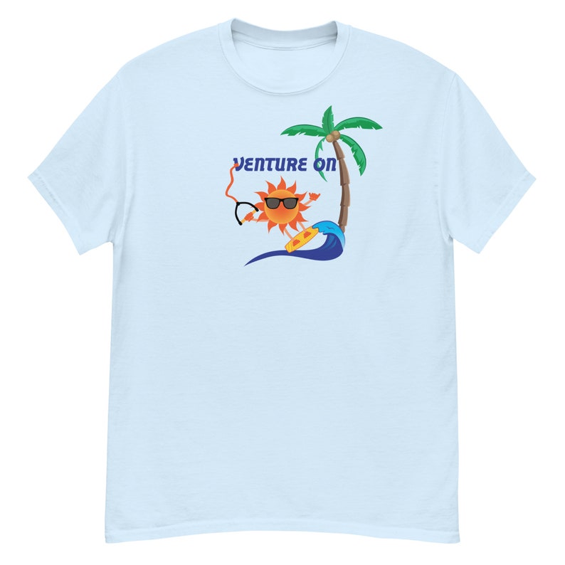 May include: Light blue t-shirt featuring a cartoon sun wearing sunglasses and riding a surfboard. The sun is orange and yellow with a smiling face. The text "Venture On" is above the sun.