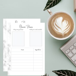 Pode incluir: Uma imagem em vista superior de um diário com o texto "Orações Pessoais" e uma xícara de café com arte latte. O diário inclui seções para gratidão e pedidos de oração. Um teclado e folhas também estão presentes.
