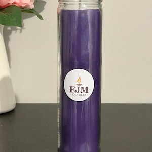 May include: A tall, cylindrical purple candle encased in a clear glass jar. A circular white sticker is centred on the front of the glass, featuring a small orange flame icon above the bold, dark text that reads FJM CANDLES.