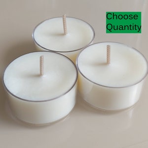 Puede incluir: Tres velas de té blancas sin aroma en recipientes de plástico transparente con mechas.